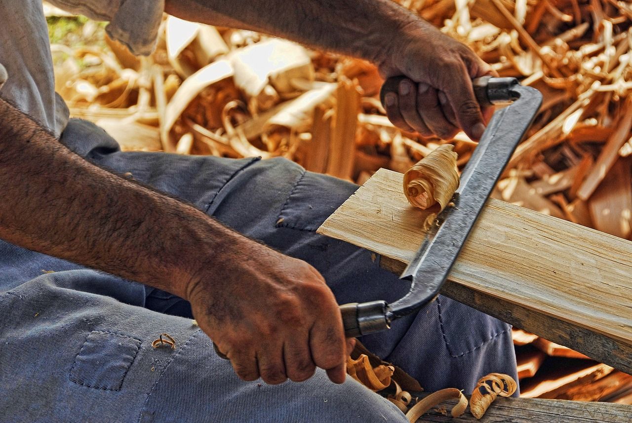Handwerker hobelt Holz